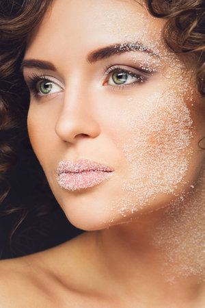 Closeup portrait of beautiful woman with white sugar on her faceの写真素材