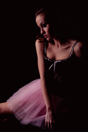 Low key portrait of beautiful girl in corset and pink toutouの写真素材