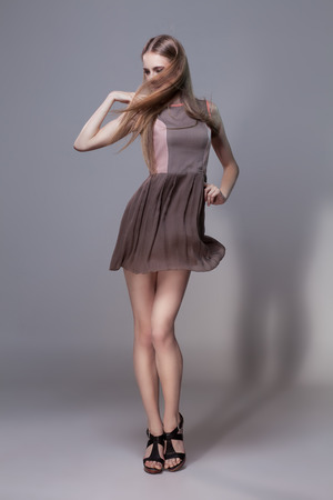 Portrait of standing beautiful girl in fashionable short dressの写真素材