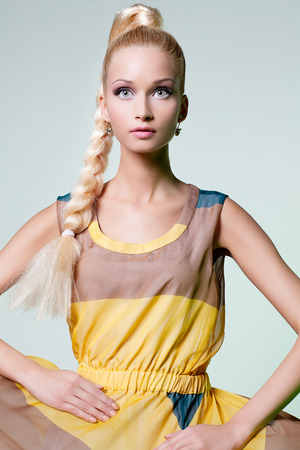 Beautiful blond girl in summer dress looking like dollの写真素材