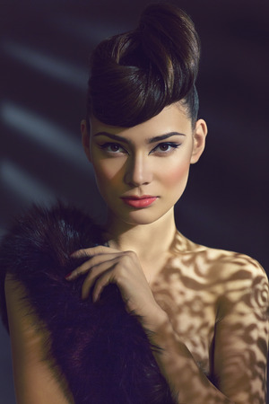 Portrait of gorgeous young woman with piece of fur on shoulderの写真素材