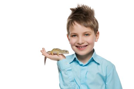 Handsome happy little boy holding pet small lizard on hand palm. Isolated over white background. Copy space.の写真素材