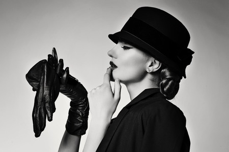 Retro beautiful young woman in black jacket and hat. Monochrome picture.