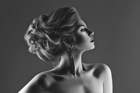 Beautiful young woman with long neck wearing earrings. Beauty shot.の写真素材