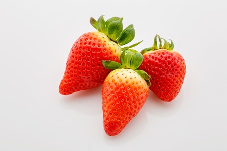 Closeup of not fully ripe strawberries. Over white backgroundの写真素材
