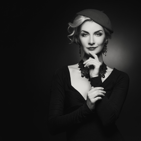 Beautiful lady in beret Over black background. Monochrome.の写真素材