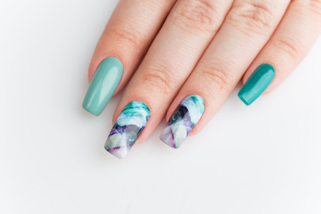 Closeup of woman nails with creative purple and green manicure.の写真素材