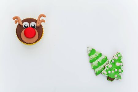 New Year cupcakes made in shape of snowman, deer and christmas candies. Over white background, Copy spaceの写真素材