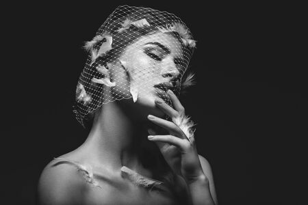 Beautiful girl in veil with feathers