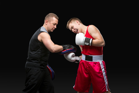 Young boxer working out with coachの写真素材