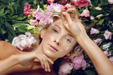 Beautiful girl lying in flowers