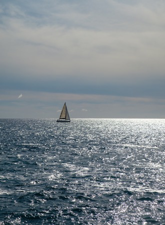 sail boat at horizon line. Pacific ocean. view from Tenerife beach. outdoor shot. copy space.の写真素材