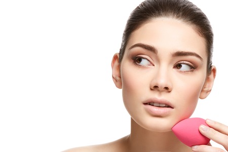 girl with makeup sponge isolated on whiteの写真素材