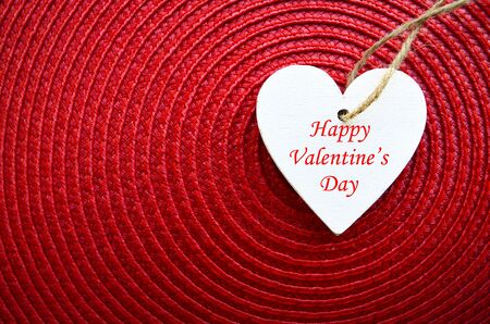 Happy Valentines Day background.Decorative white wooden heart on red straw napkin with copy space.Saint Valentine's Day concept.Selective focus.Saint Valentine's Day concept.の写真素材