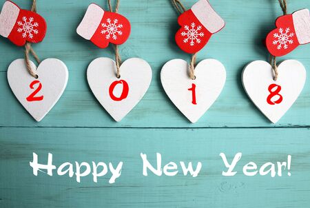 Happy New Year 2018.Decorative white wooden Christmas tree and red mittens on blue wooden...
