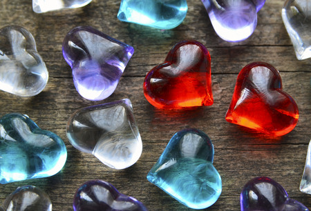 Valentines Day background with colorful glass hearts.Two red transparent glass hearts among many others.St Valentine's Day or Love concept.Selective focus.の写真素材