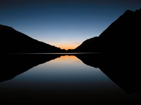 Peaceful Sunset Reflected Over Mountain Lakeの写真素材