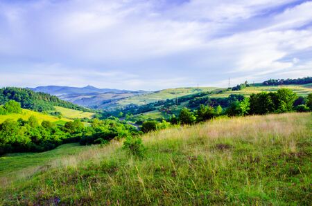 Summer mountain landscape, green hills and trees in the warm sunny day