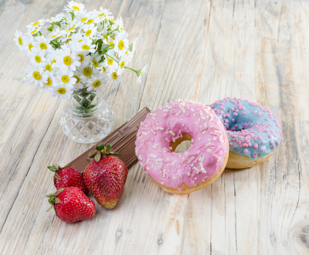 Strawberries on the table. Red strawberries on a wooden table in a glass vase. chocolate and soft buns.の写真素材
