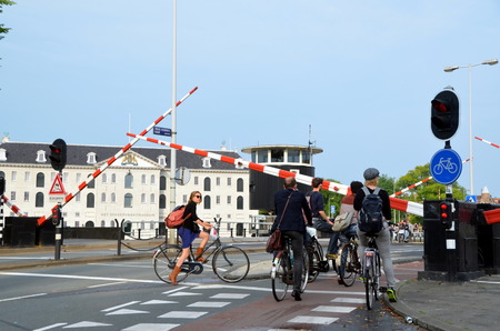  Cyclists wait  for the gate to be opened, Amsterdam, The Netherlands のeditorial素材