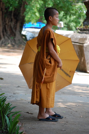 Young buddhist monk with an umbrella from the sunのeditorial素材