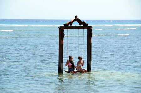 Two girls are on a swing in the ocean. Gili Trawangan Island, Indonesiaのeditorial素材