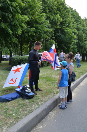 Saint-Petersburg, International Maritime Defence Show 2015 IMDS-2015. Young man sells flagsのeditorial素材