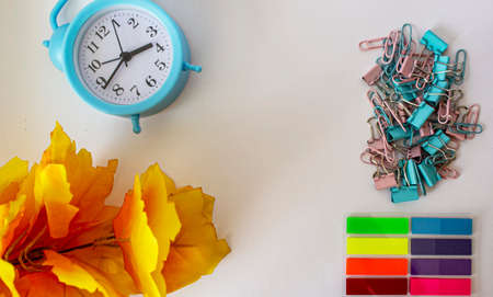 Stickers, paper clips, alarm clock and yellow maple leaf. Stationery for your office.の写真素材