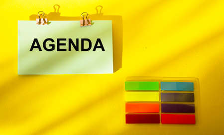 On a yellow background tex Agenda, next to it are colored stickersの写真素材
