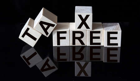 TAX FREE words on wooden cubes and glass black background with reflection.の写真素材