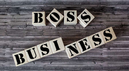 Business concept .On a wooden table, cubes with the text boss and business.の写真素材