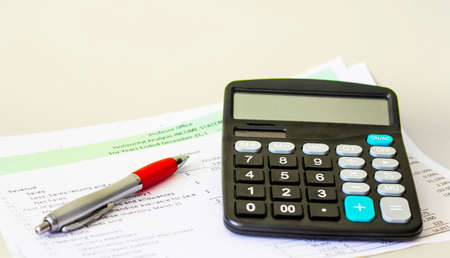 Business concept. Financial calculator, pen and growth charts.