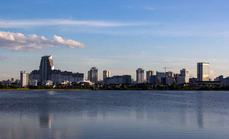 Panorama of the skyline of Minsk through Lake Drozdy in the daytime. Water smoothness with...