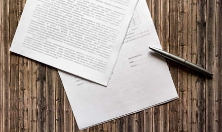 Pen and contract papers on wooden deskの写真素材