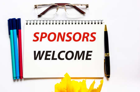 WELCOME SPONSOR word written on notepad with pen, glasses and felt-tip pens on white backgroundの写真素材