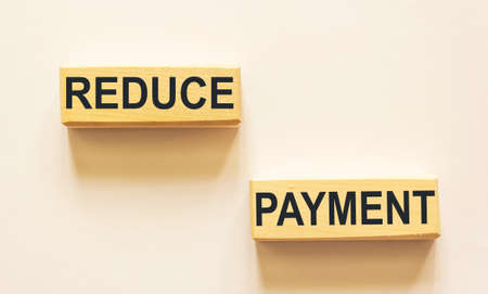 Wooden blocks with the words Reduce payment. Business concept.の写真素材