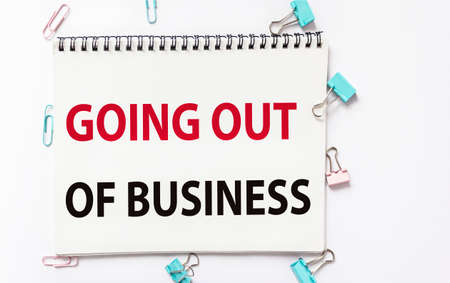 On a notebook the text GOING OUT OF BUSINESS, on a white backgroundの写真素材