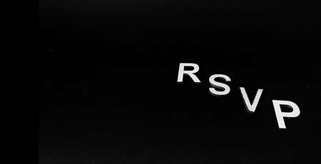 Wooden letters RSVP on a black background. There is a place for textの写真素材