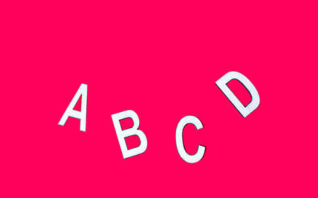 Wooden letters of the alphabet ABCD on a red background. The beginning of the alphabet