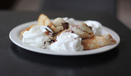 Pancakes with whipped cream on a summer terrace, dark backgroundの写真素材