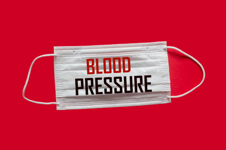 BLOOD PRESSURE, text written on medical mask and red background.の写真素材