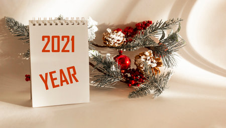 On a white background lies a fir branch with New Year's toys and a calendar with the text 2021 yearの写真素材