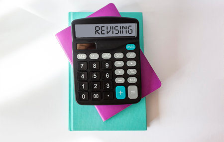 Revising, text on the calculator. Multi Colored notepads on white backgroundの写真素材