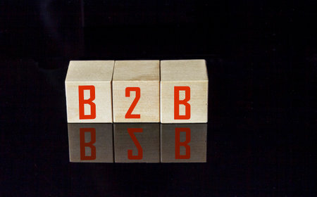 Acronym B2B- Business to Business. Wooden small cubes with letters isolated on black background with copy space available. Business Concept image.の写真素材