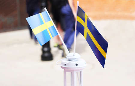 Close-up of Swedish flags in a miniature white lamp.の写真素材