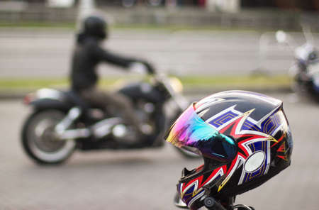 Bright motorcycle helmet in focus and out of focus motorcycle with motorcyclist