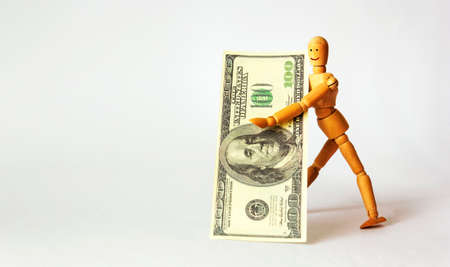 happy wooden mannequin businessman with 100 dollar banknoteの写真素材