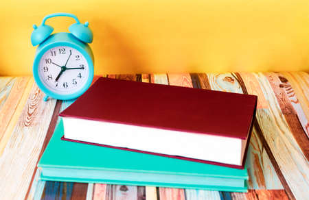 Alarm clock and two notepads on the desktop.の写真素材