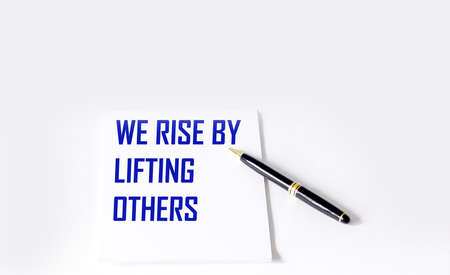 Quote with inscription on a white notebook about the life and work we raise by helping othersの写真素材
