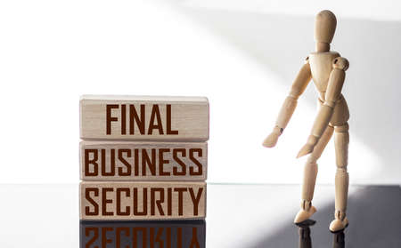 text FINAL BUSINESS SECURITY. The text is written on wooden blocks, on a white and black background...